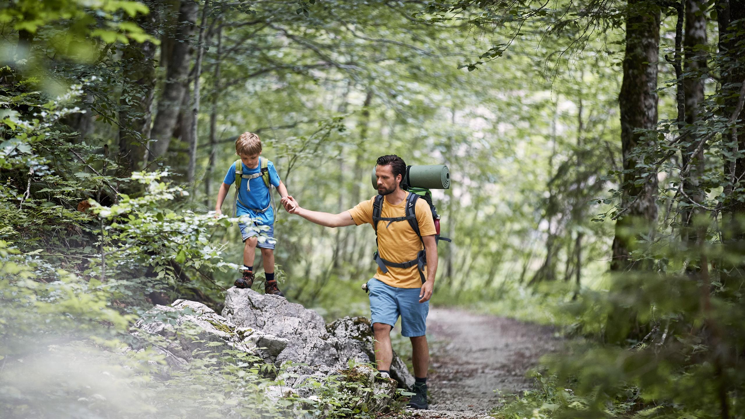 Otec a syn na pěší túře po lesní cestě