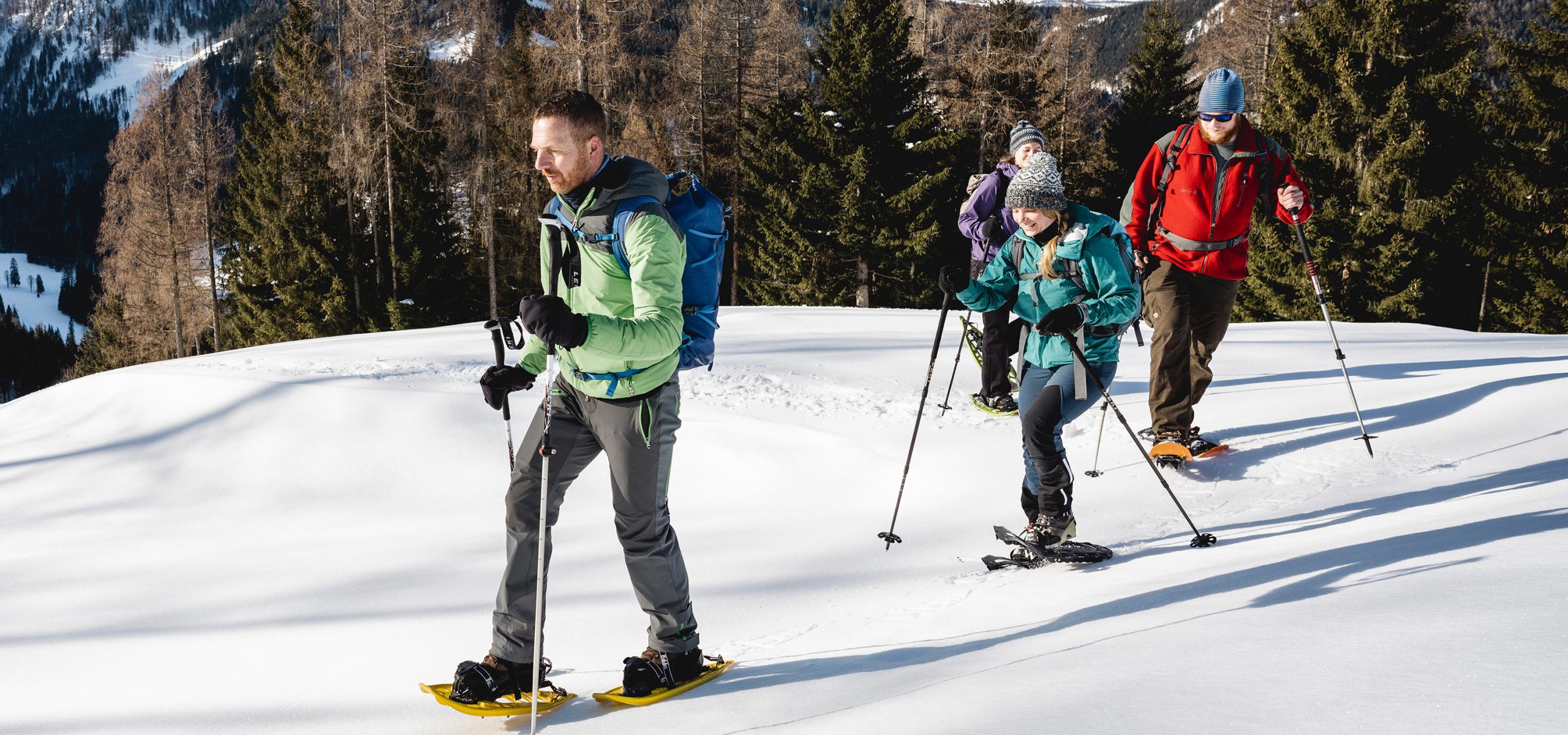 Strážce národního parku doprovází tři dospělé na túře na sněžnicích