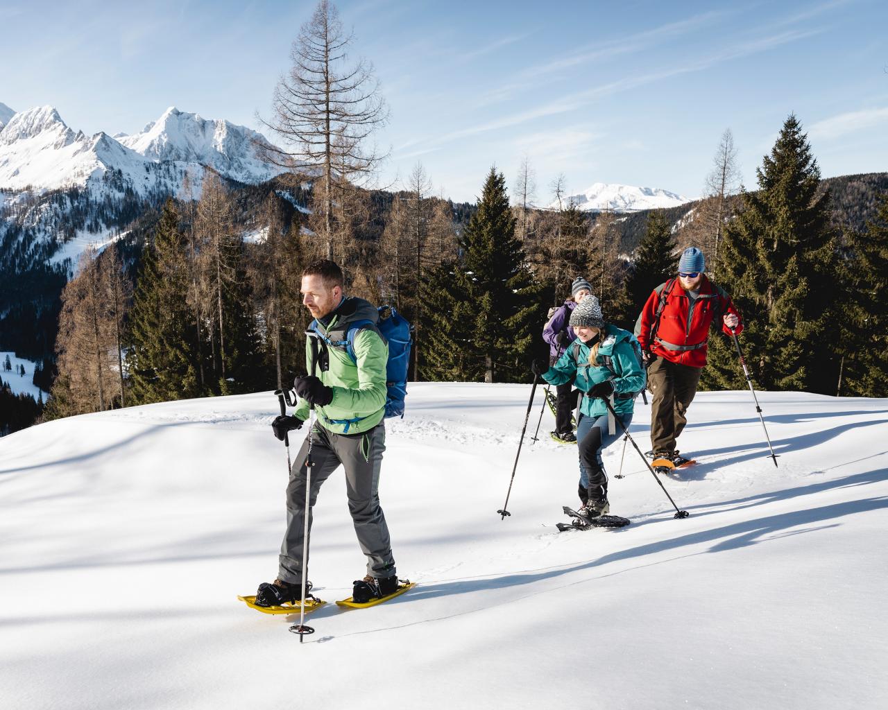 Strážce národního parku doprovází tři dospělé na túře na sněžnicích