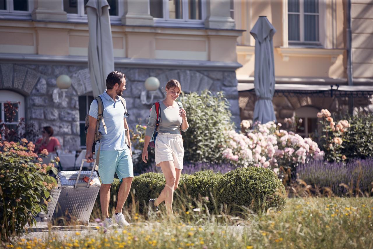 Muž a žena přicházejí do hotelu s batohy a kufry