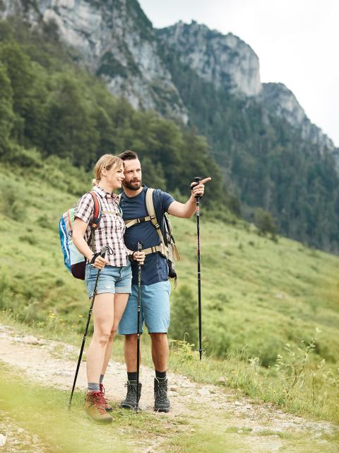 Žena a muž v turistické výstroji se rozhlížejí kolem sebe