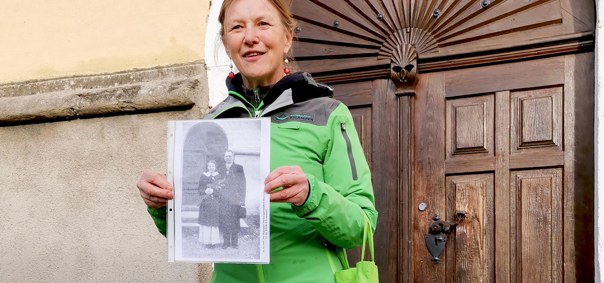 Ranger stojí před portálem kostela a v ruce drží starou svatební fotografii Marlen Haushoferové.