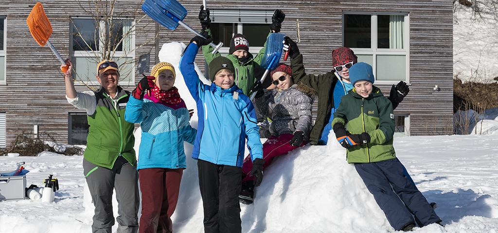 Ranger a skupina dětí staví sněhovou sochu