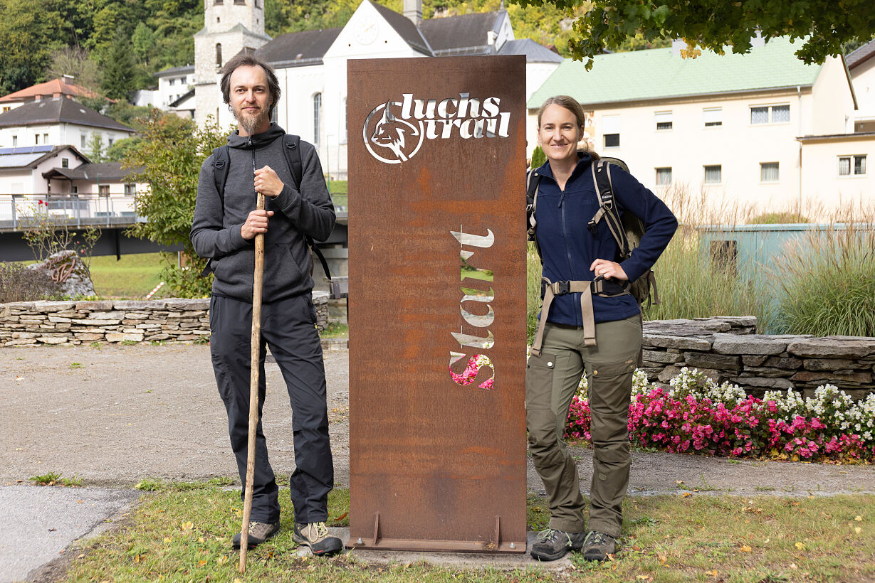 Marc Graf a Christin Sonvilla stojí u železného pomníku s nápisem Luchs Trail Start.